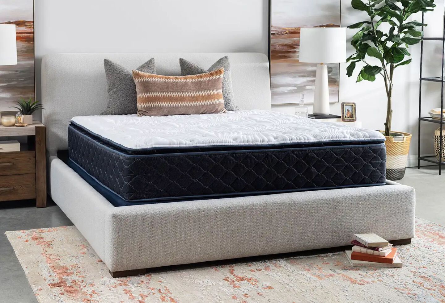 Navy blue and white mattress on top of a light grey bedframe in a bedroom
