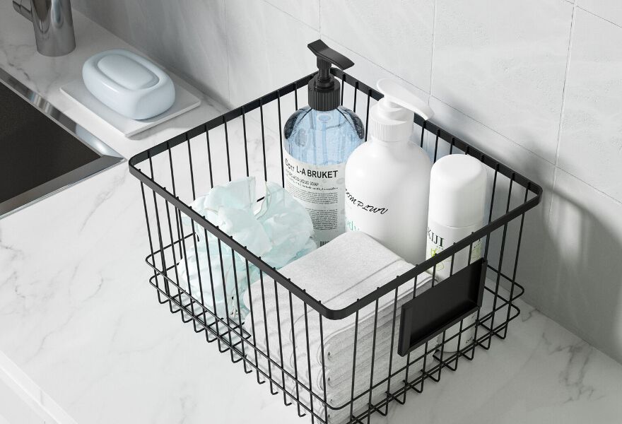 Bathroom counter with a black wire basket with several bathroom products within