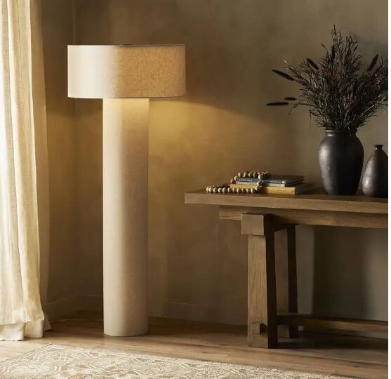 Tan colored modern floor lamp in a neutral colored room.