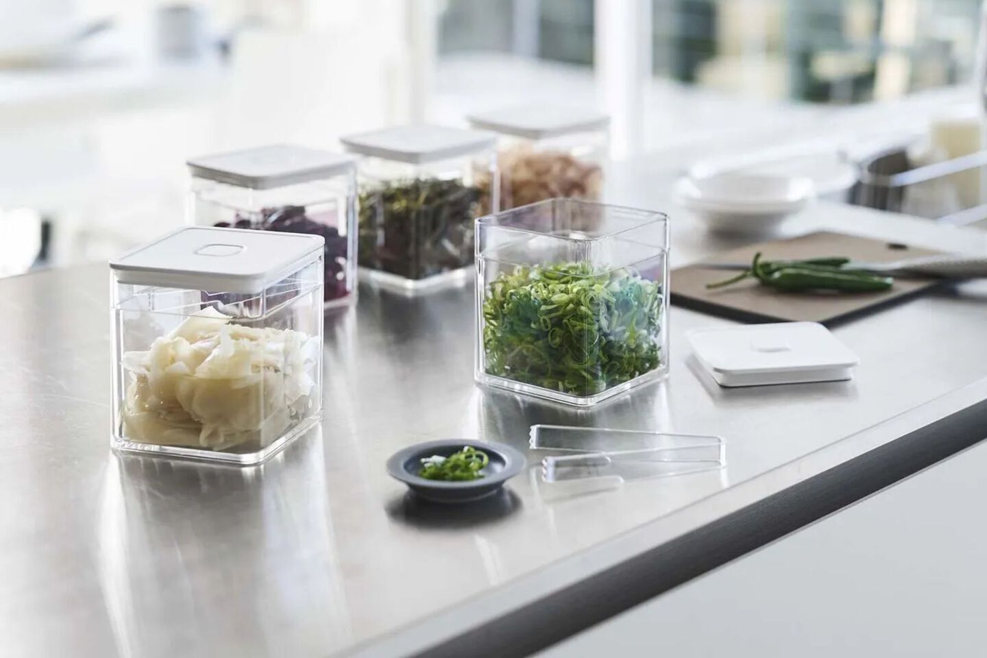 Countertop with small white and clear plastic containers filled with herbs on top