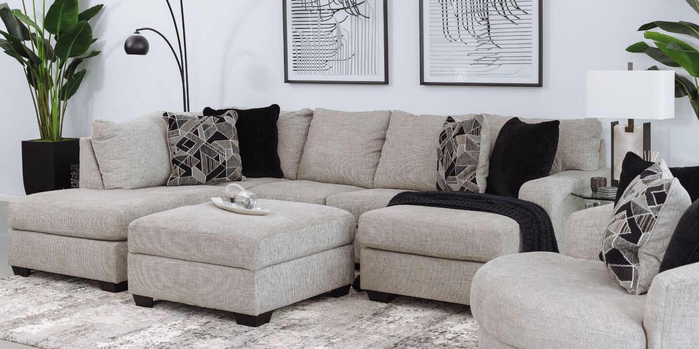 Light grey sectional couch with black and grey pillows