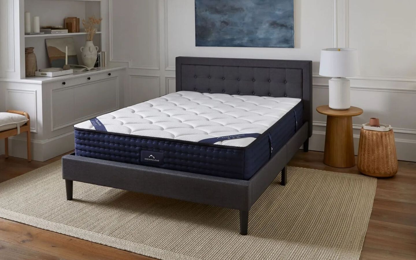 Navy and white mattress on a dark grey upholstered bedframe