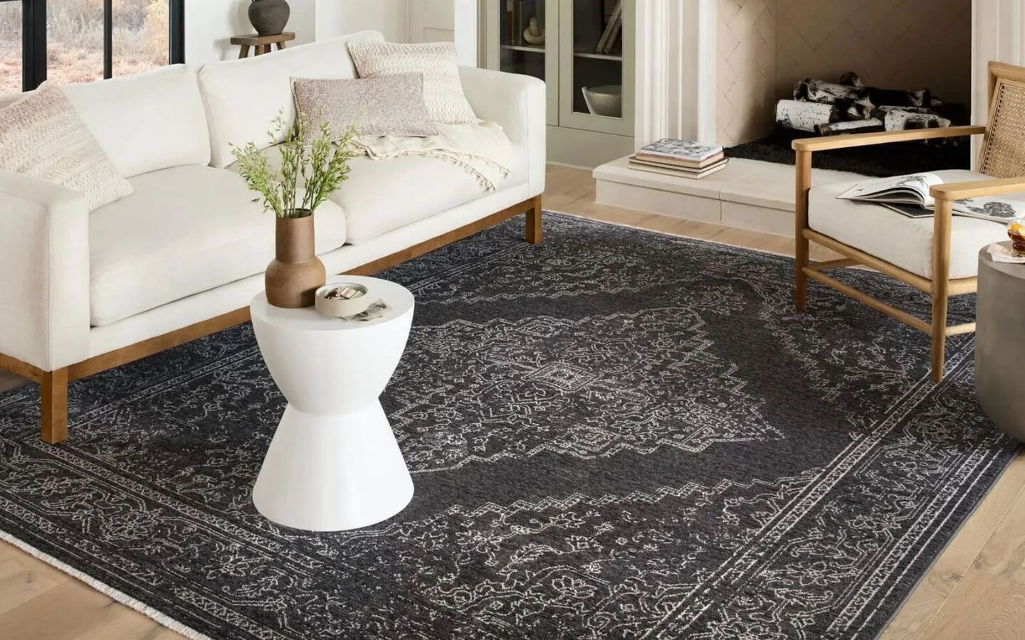 Living room with white and light wood furniture on top of black and white rug