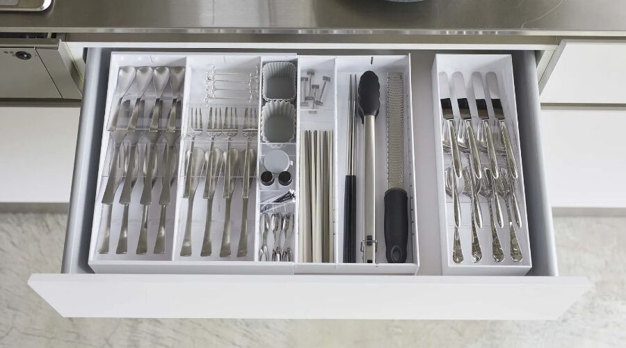 Open kitchen drawer with a utensil organizer filled with utensils inside