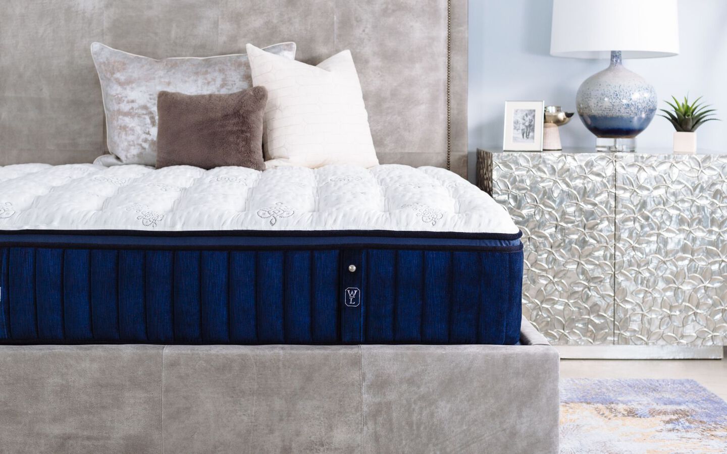 Navy blue and white William & Lawrence mattress next to a silver nightstand