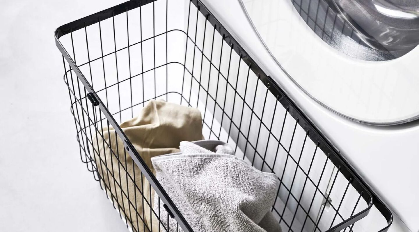 Aerial view of a black wire laundry hamper filled with clothes