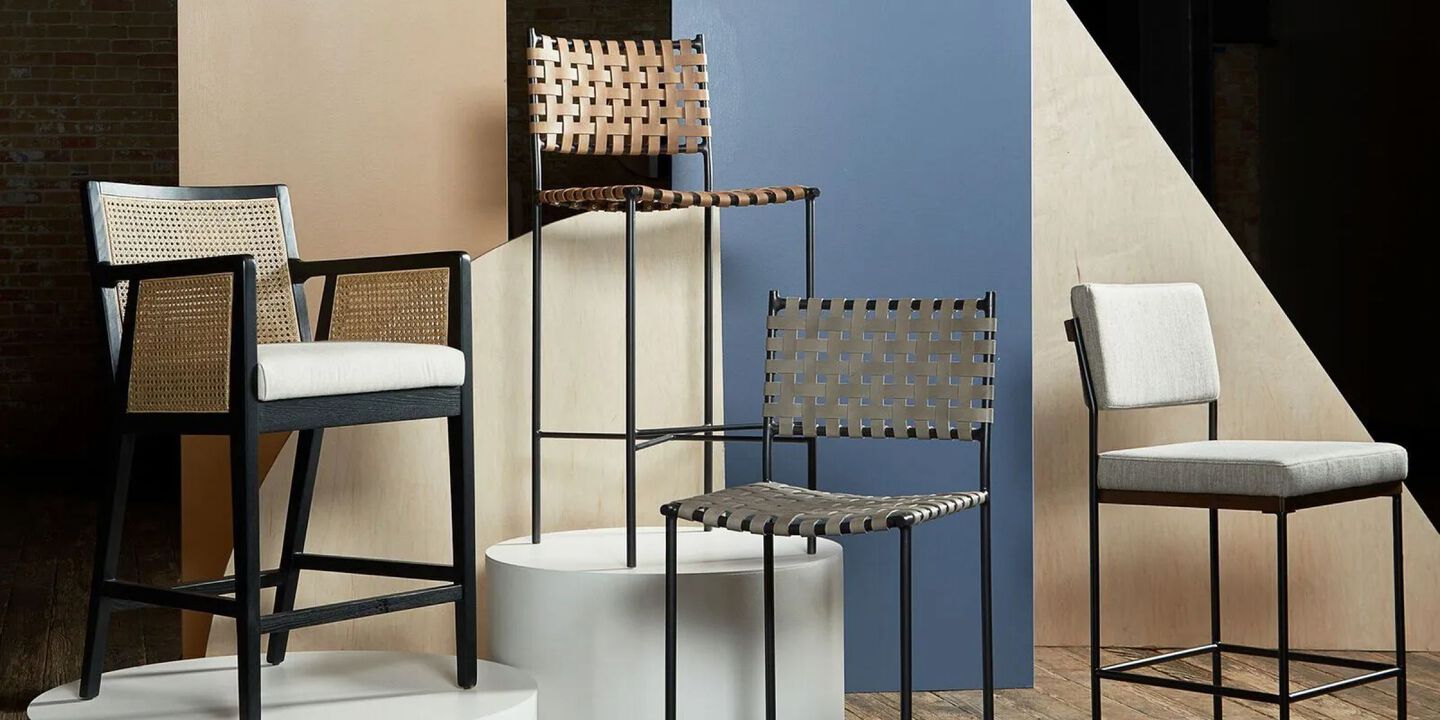 Four different bar stools positioned on podiums lined up in a room