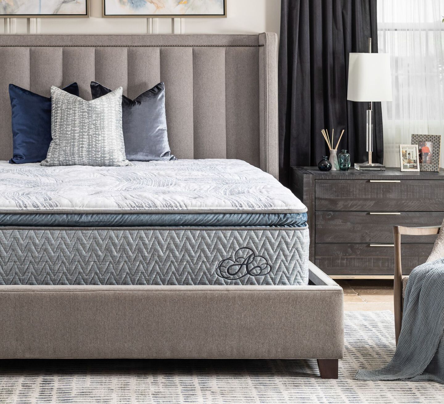 Bedroom with light blue Americana mattress on a beige bedframe and a dark brown nightstand