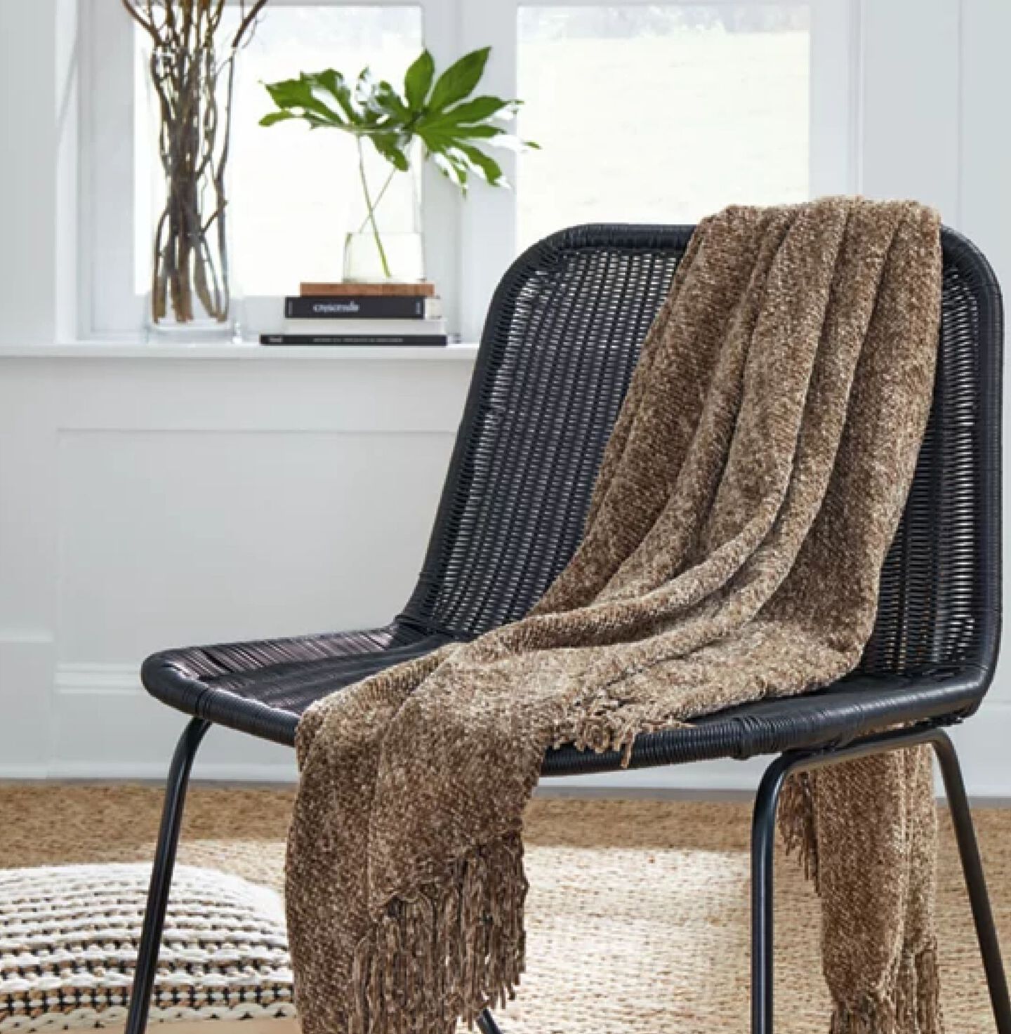 Single black chair with a brown plush blanket draped over it