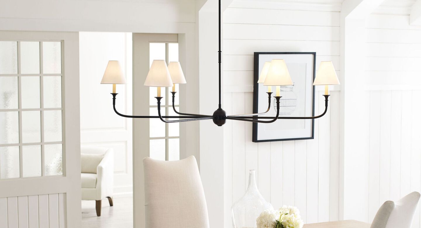 Black and white light fixture hanging from the ceiling above a dining table