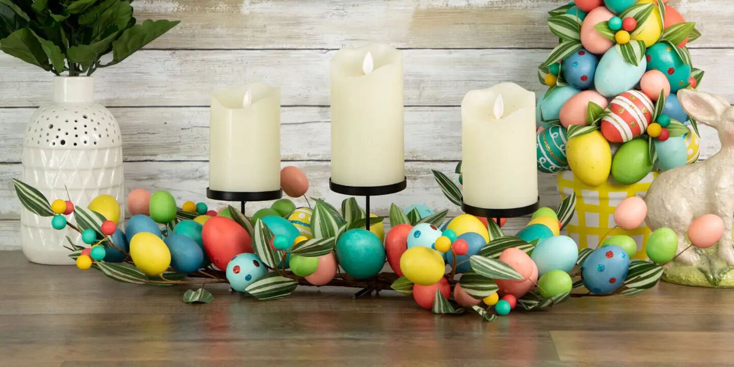 Table with a colorful egg centerpiece with three white candles