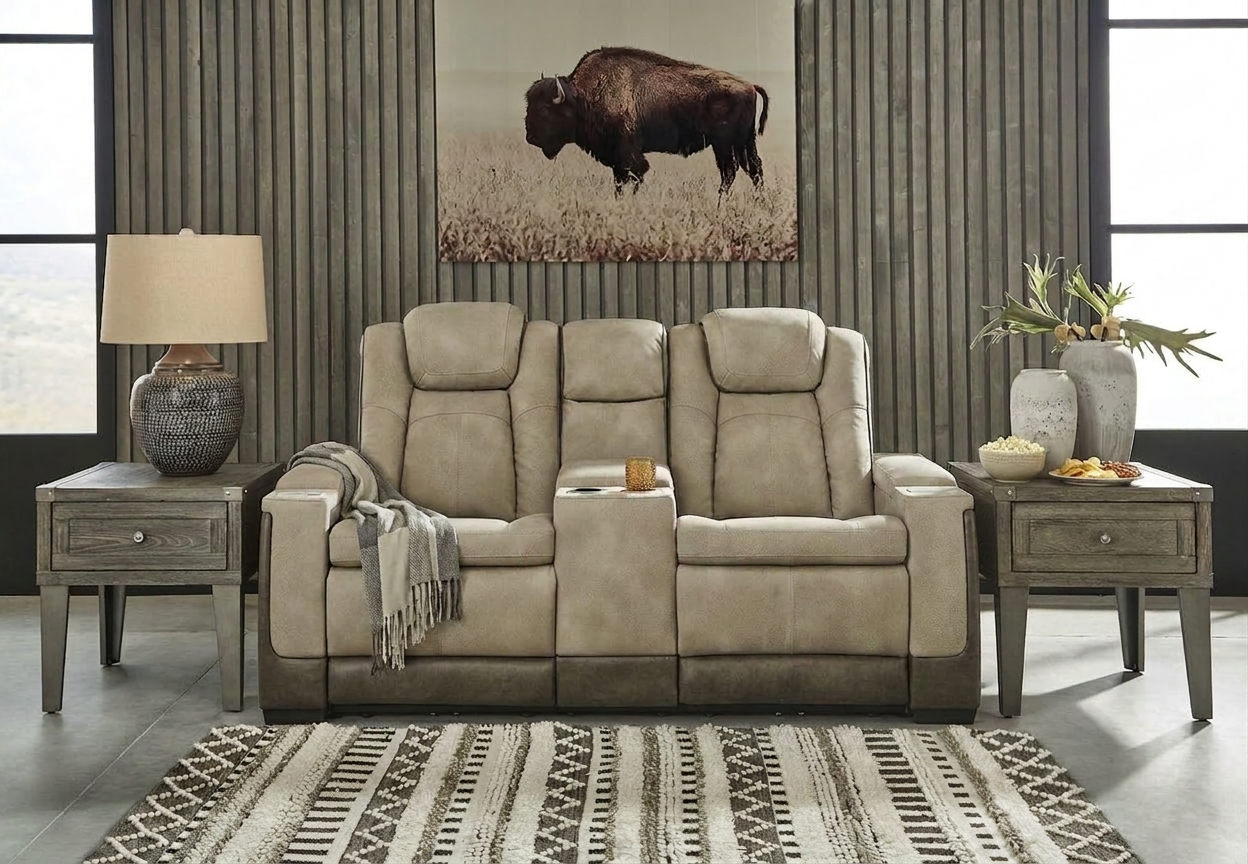 A tan colored theater style reclining loveseat with snacks on the side, ready for a soccer game watch party.