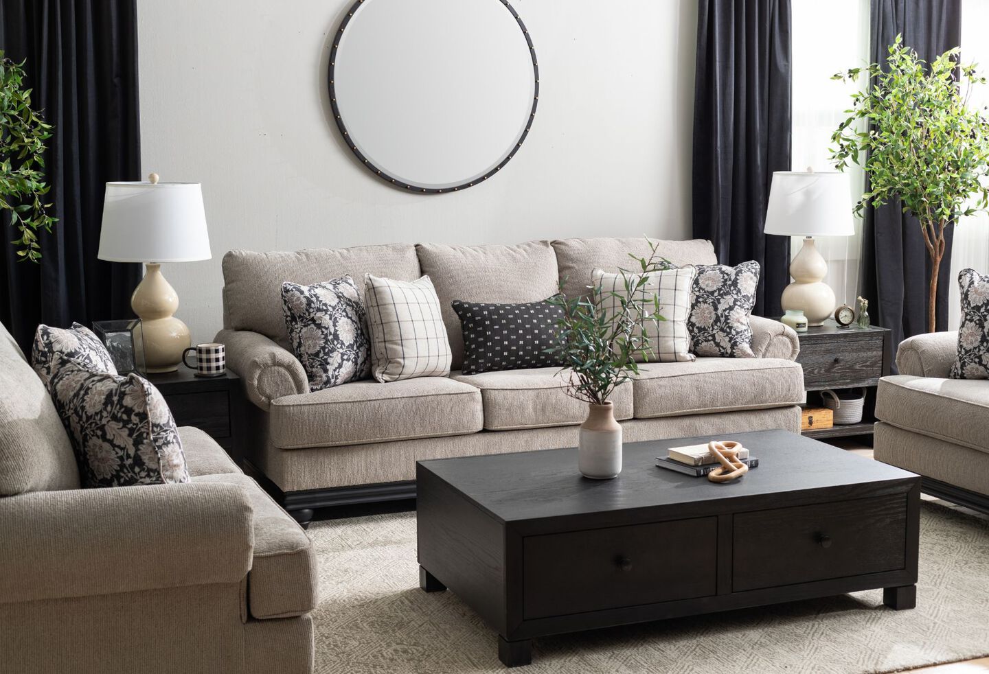 Living room with light grey couch and loveseat, black coffee table, and two black side tables