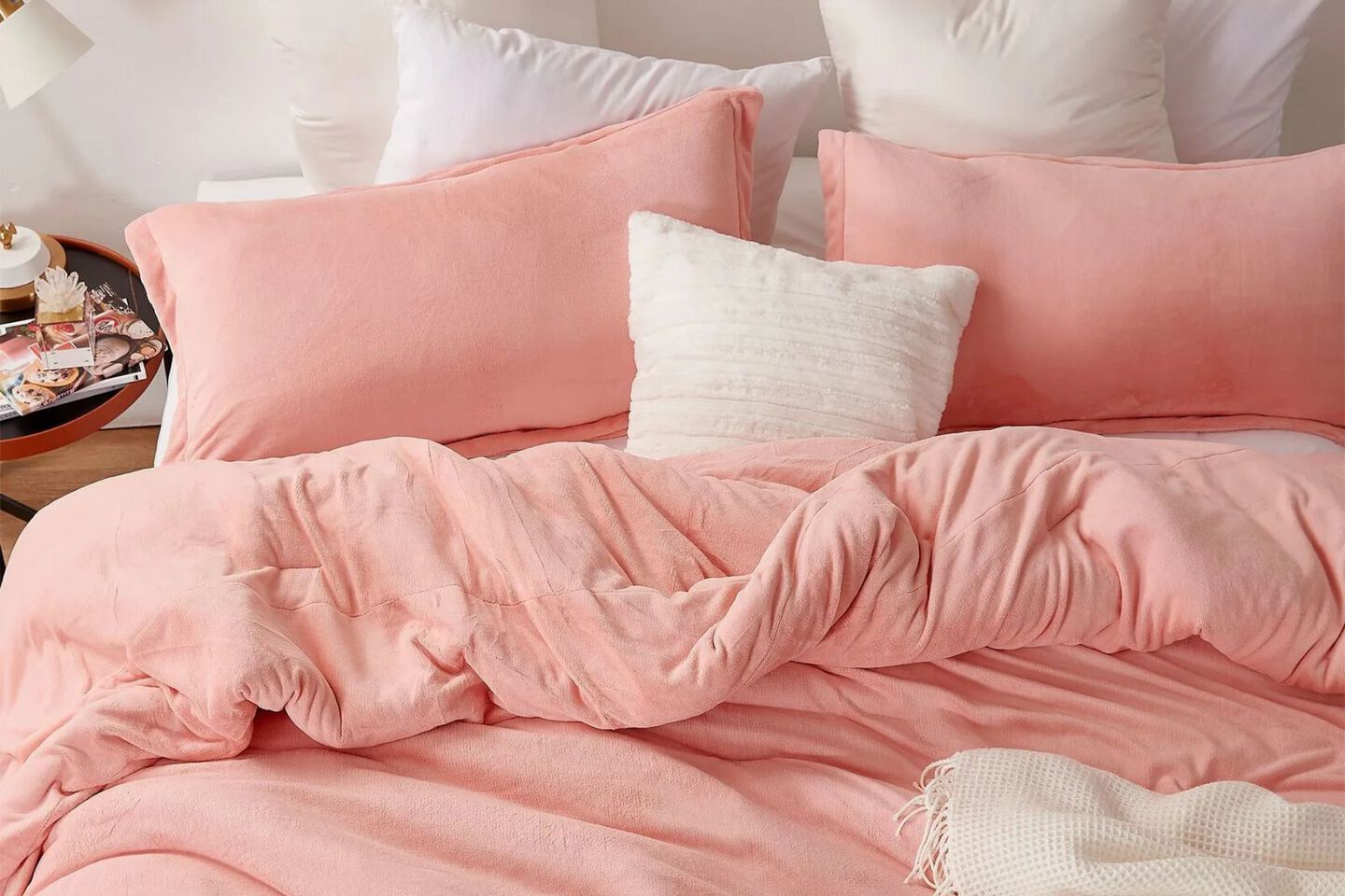 Bed with a peach-colored comforter and peach and white pillows