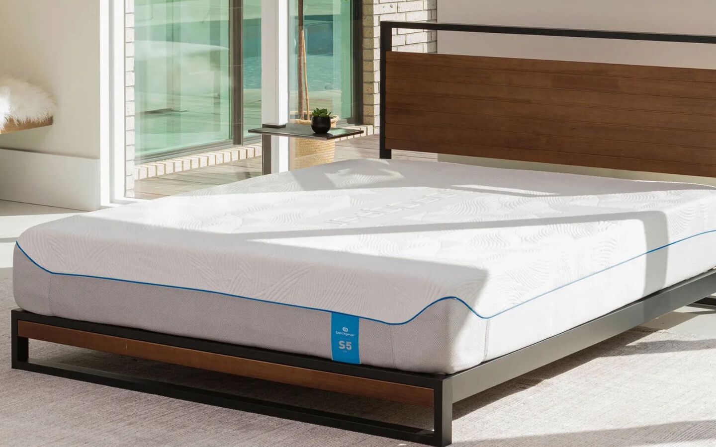 Plain mattress on a black and wood bedframe