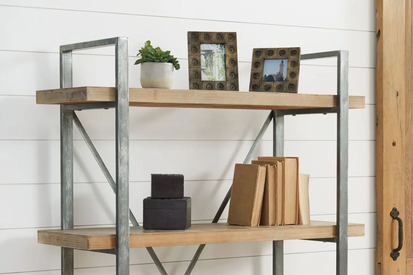Wood and metal shelf with books and picture frames sitting on the shelves