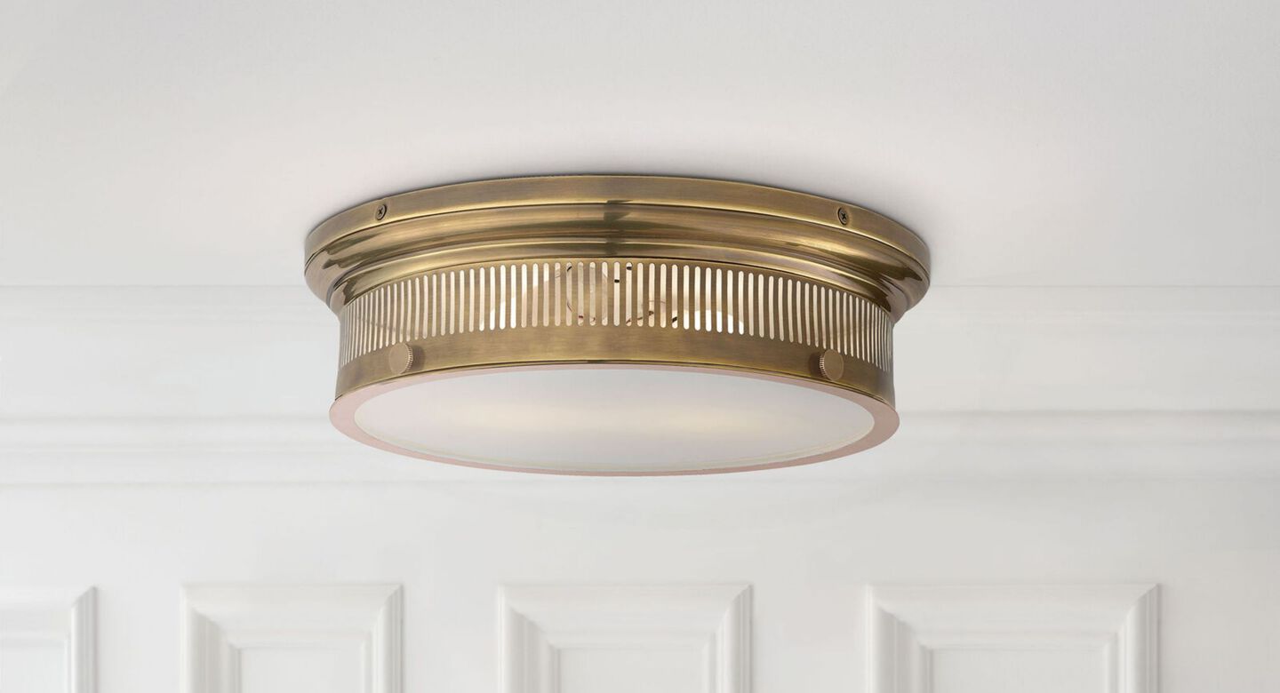 Round gold light fixture attached to a solid white ceiling