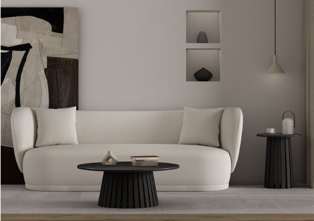 Round black modern coffee table with minimalist decor on top.