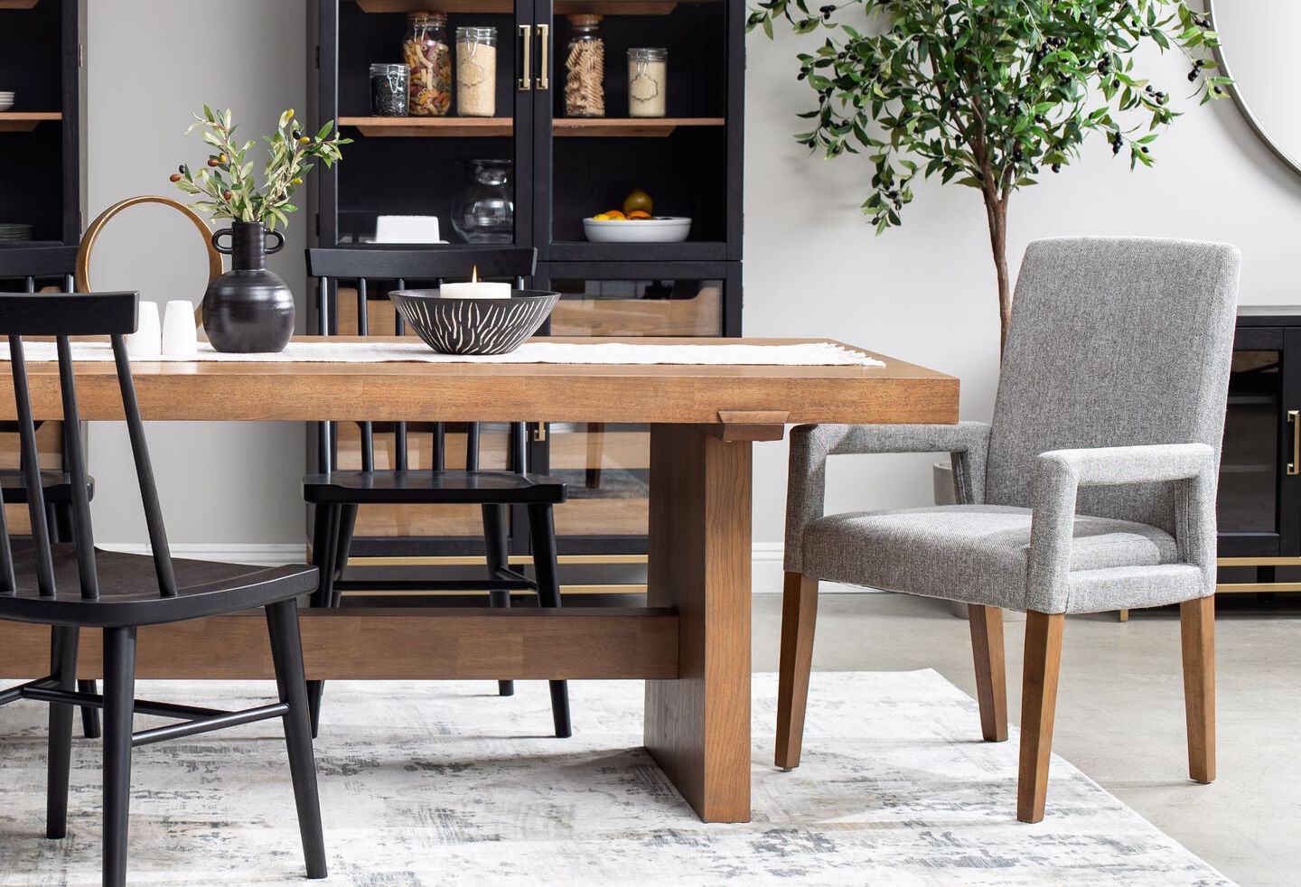 Dining room with black cabinet, wooden table, and grey and black chairs