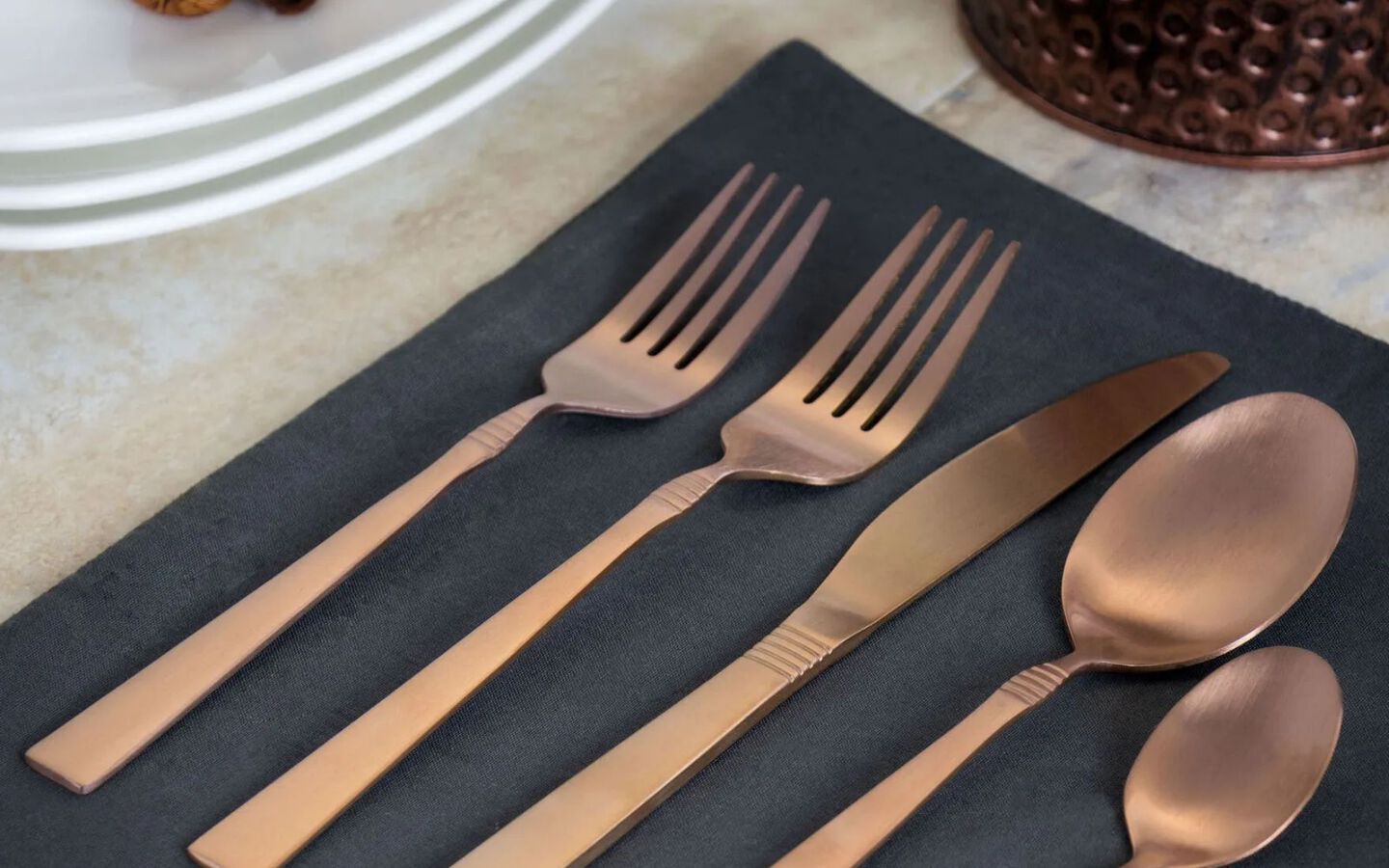 Closeup of bronze silverware on a black napkin