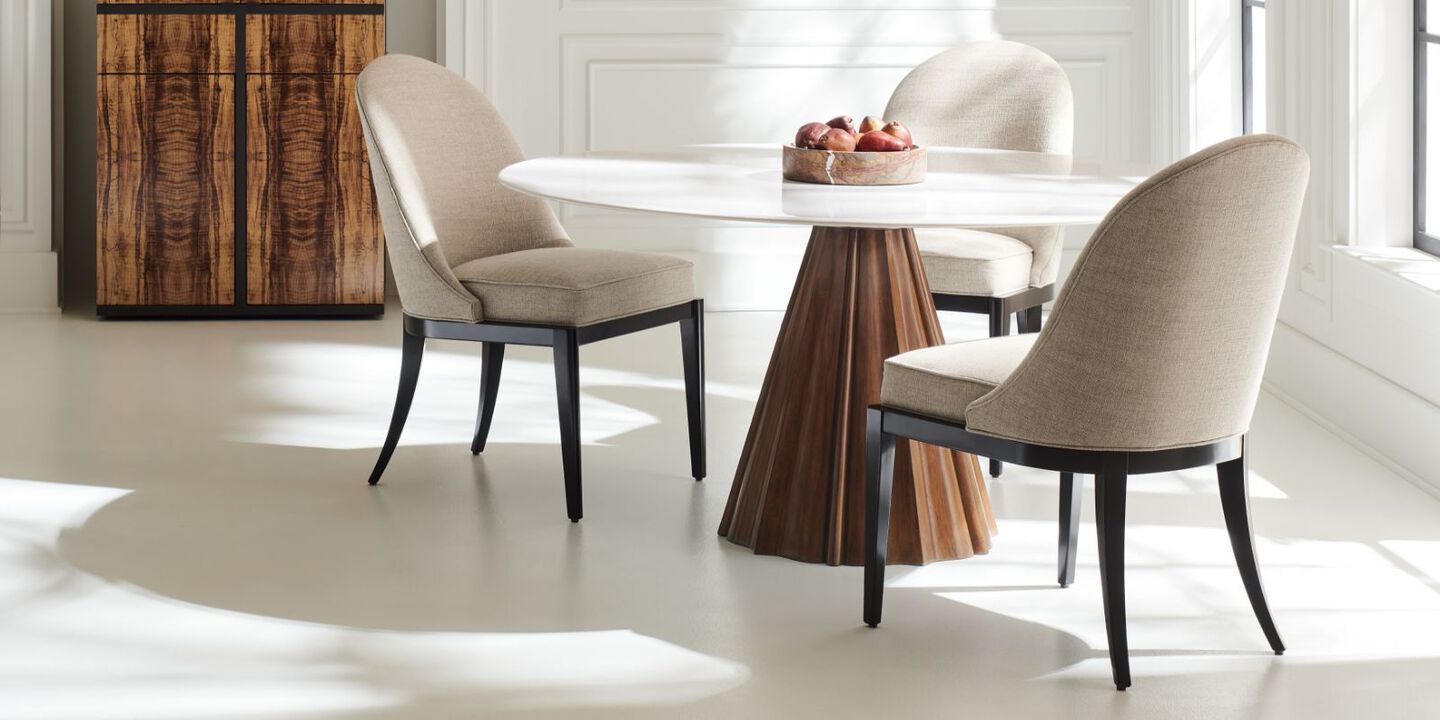 brown and white dining table surrounded by three beige and black chairs