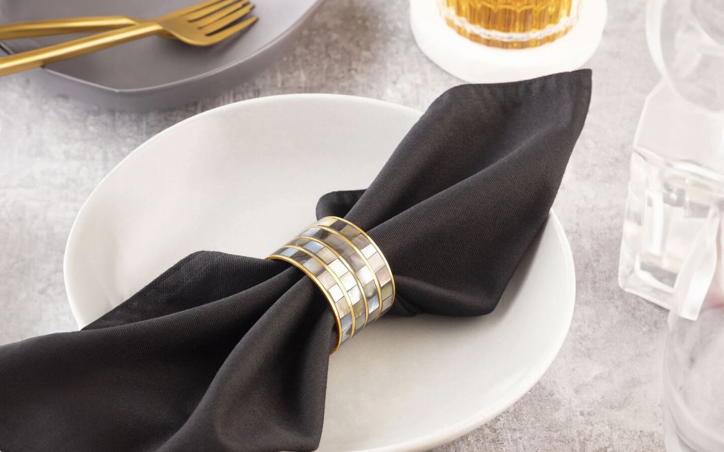 Closeup of black napkin folded on top of a white plate