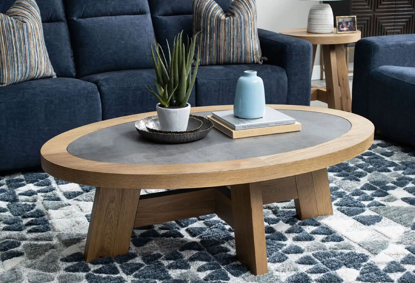 Living room with wooden coffee table, blue rug, and blue plush couch and chairs