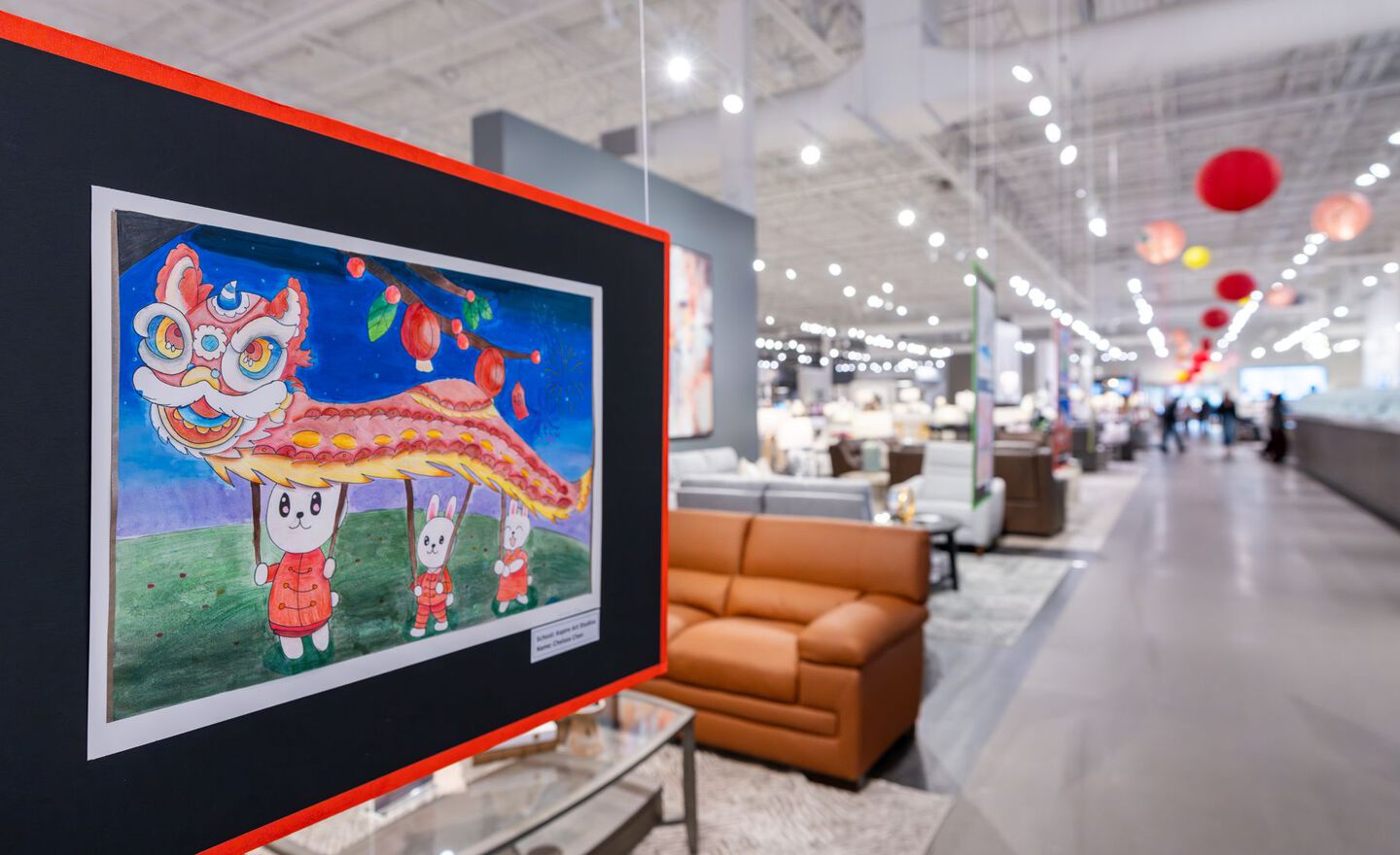 A child's drawing of a dancing dragon puppet hanging in the Mathis Home store