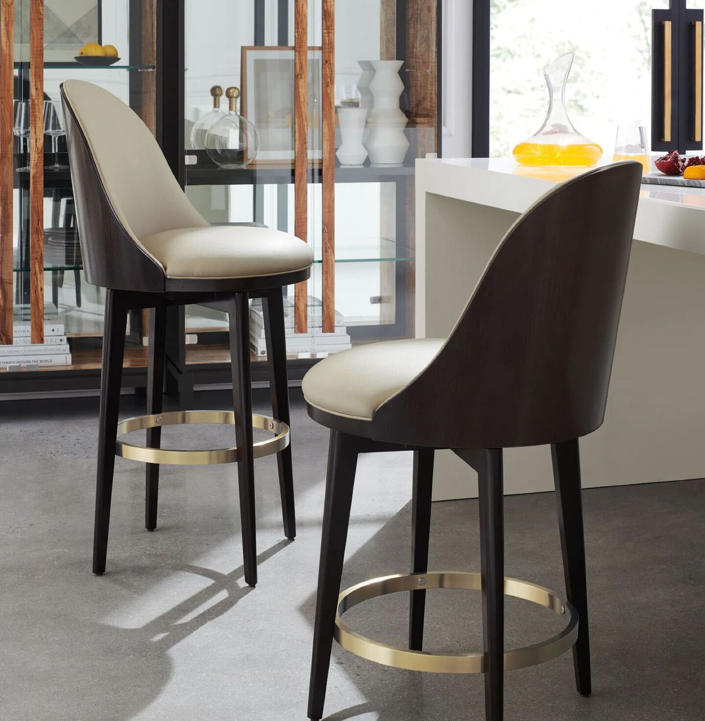 Two barstools with tan leather seats, brown backs, and gold hardware in a kitchen