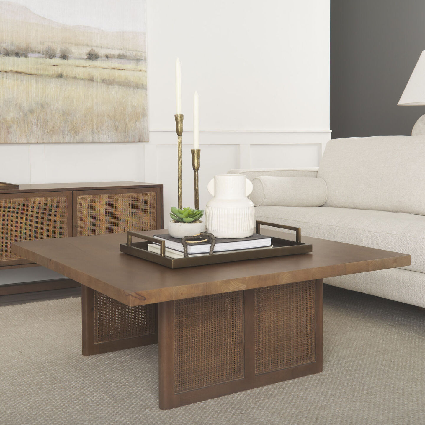 A minimalistic tray on a coffee table with decorative items placed at various visual heights.