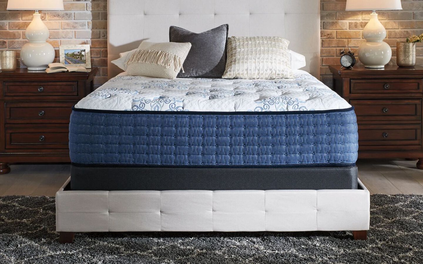 Blue and white mattress on top of a white bedframe in a bedroom