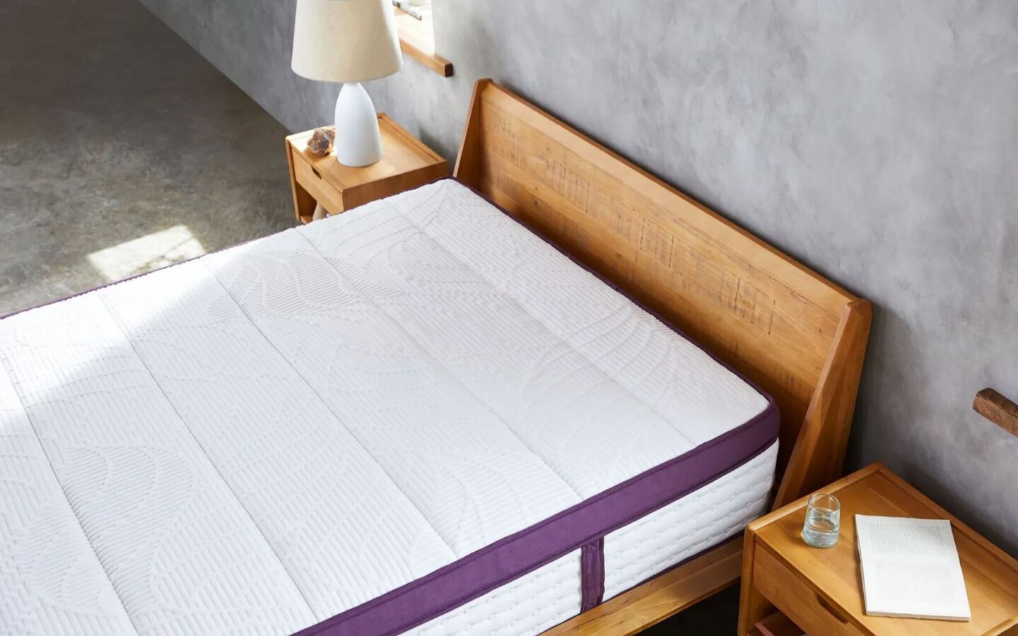Aerial view of a purple and white mattress on top of wooden bedframe
