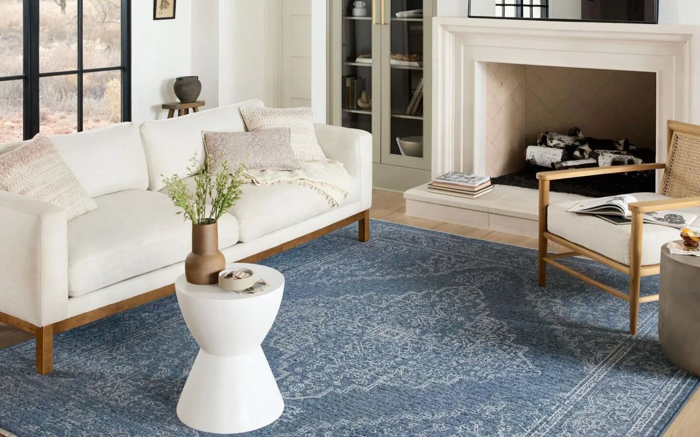 living room with white couch, white side table, and a blue patterned rug