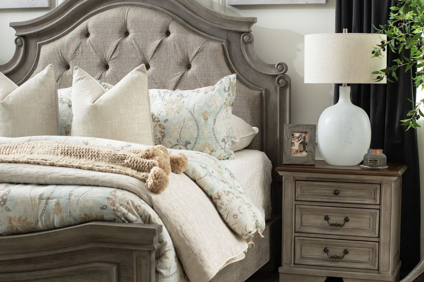 Bedroom with grey upholstered bed and matching nightstand