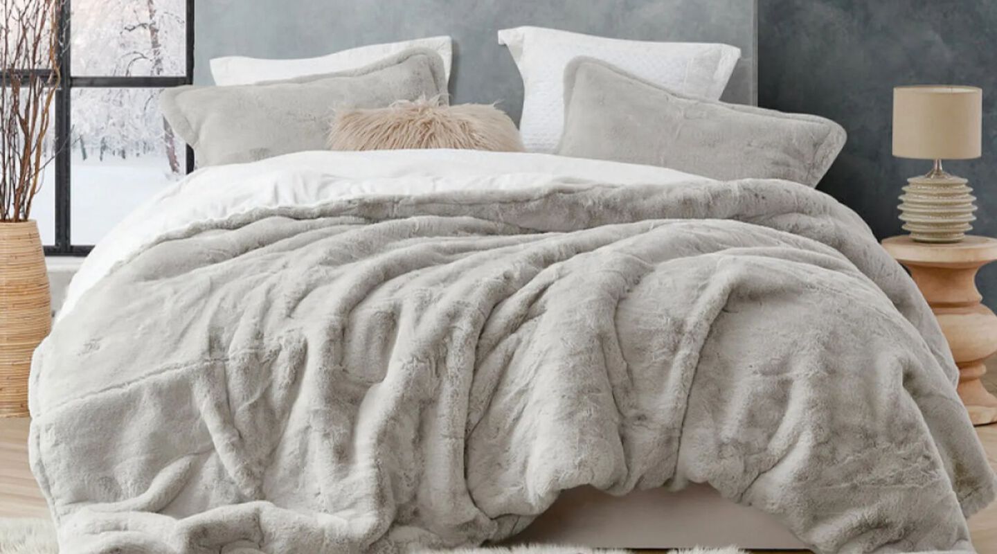 Bed with light grey comforter and matching light grey pillows