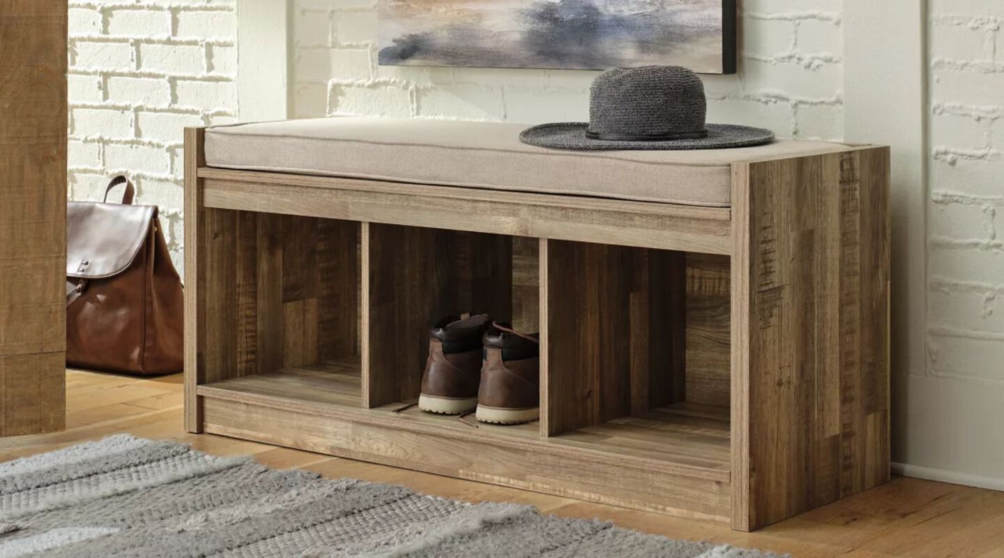 Entryway storage cabinet with shoes inside and a hat on top