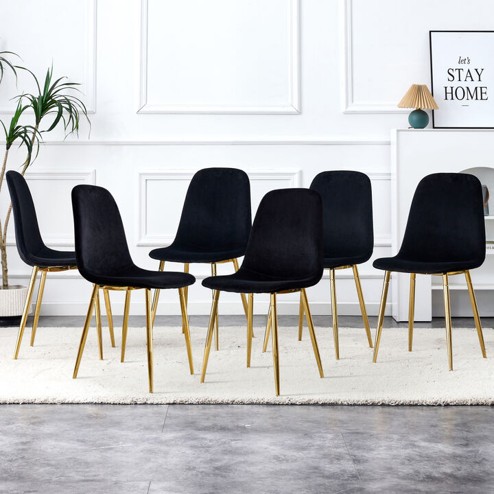 A set of 6 dining chairs, featuring modern medieval style restaurant cushioned side chairs with soft velvet fabric covered cushions and golden metal legs in a spoon shaped feature. B0501A