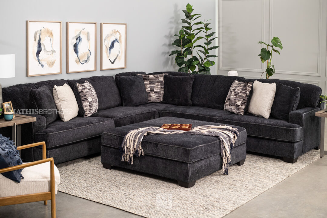 Lavernett Square Ottoman in charcoal in a living room setting in front of a matching sectional.