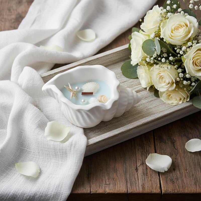 HomeRoots 6" Unscented Soy Wax Candle In White Resin Novelty Holder With Seashells image number 1