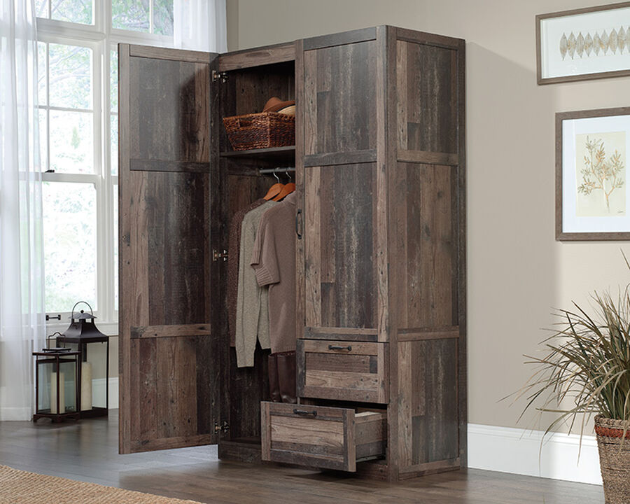 This large wardrobe cabinet features a garment rod and a fixed shelf behind its full-length door for storage